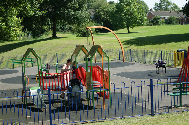 A woman and a child playing in a play area.